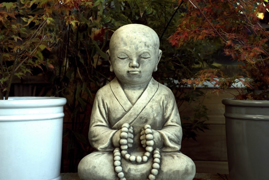 Estátua de menino meditando